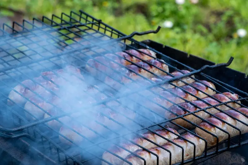 Saucisses cuites au brasero avec de la fumée abondante