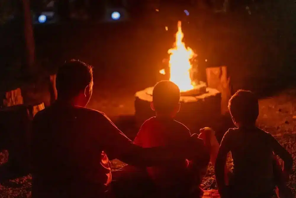 Famille autour d'un brasero sous une nuit chaleureuse